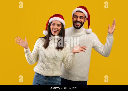 Glückliches Paar, das die Feiertage mit einem hellen Lächeln und festlicher Kleidung feiert Stockfoto