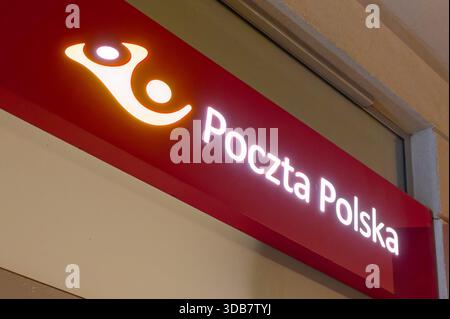 Poczta Polska Postschild mit beleuchtetem Logo und Schriftzug an der Gebäudefassade, polnischer Postdienst. Stockfoto