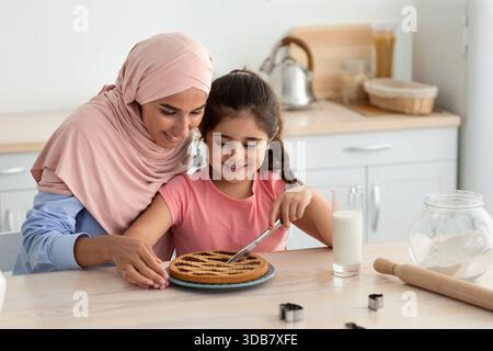 Mutter und Tochter genießen die gemeinsame Backzeit in der Küche und bereiten ein Dessert vor Stockfoto