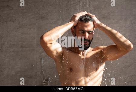 Schönes junges arabisches männliches Model mit erfrischendem Duschbad Stockfoto