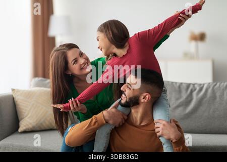 Fröhliche arabische Familie genießt eine gute Zeit zu Hause, während sie gemeinsam spielt und lacht Stockfoto