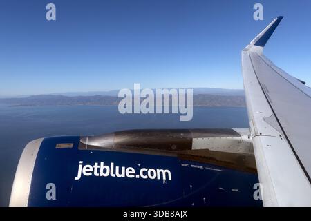 Der Flügel und der Motor eines JetBlue-Flugzeugs werden kurz nach dem Abflug von Los Angeles im Flug über dem Pazifik gesehen. Stockfoto