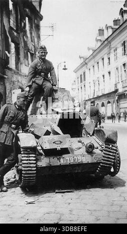 Der Renault AMR-33 (die AMR-Deignation deutet darauf hin, dass es sich um ein Aufklärungsfahrzeug im Vergleich zum AMC-Kampfnamen handelte) war ein leichter Panzer zwischen den Kriegen. Insgesamt wurden 123 gebaut und obwohl es schnell war, war es unzuverlässig. Im 2. Weltkrieg wurden 75% der Flotte in der ersten Woche der deutschen Invasion verloren. Dieses Bild zeigt deutsche Truppen mit einem verlassenen AMR-33 in Orleans im Jahr 1940. Stockfoto
