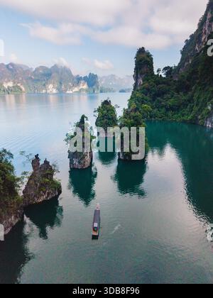 Erkunden Sie die atemberaubenden Ausblicke auf den Cheow Lan Lake, umgeben von hohen Kalksteinklippen und üppigem Grün. Khao Sok, Thailand Stockfoto