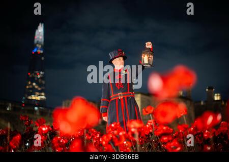 ÜBERPRÜFUNG DER PA FÜR DAS JAHR 2025. Dateifoto vom 25. 11. November: Ein Tower of London Yeoman Warder (Beefeater) hält eine Laterne an einer Ausstellung von Keramikmohn, während der Tower den Waffenstillstand begeht. Ausgabedatum: Montag, 15. Dezember 2025. Stockfoto