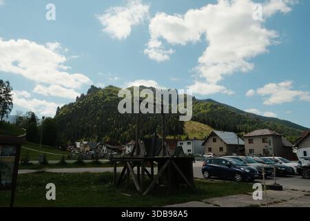 Charmante Dorfszene in der Nähe bewaldeter Berge, mit einer ungewöhnlichen Holzkonstruktion, wahrscheinlich historisch. Stockfoto