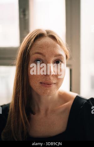 Eine rothaarige Frau mit Sommersprossen schaut in die Kamera Stockfoto