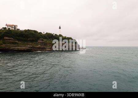 Blick aus der Vogelperspektive auf den ikonischen Leuchtturm, der hoch auf einer Klippe steht, mit Blick auf den riesigen Ozean mit einem Gebäude am Klippenrand, Biarritz, Nouvelle-Aquita Stockfoto