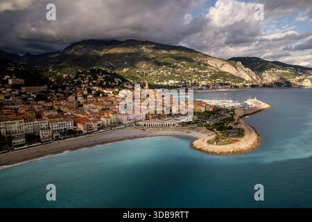 Aus der Vogelperspektive des goldenen Sonnenlichts, das die Terrakotta-Dächer der Altstadt küsst, steht im Kontrast zum azurblauen Meer und der schützenden Hafenmauer Mento Stockfoto