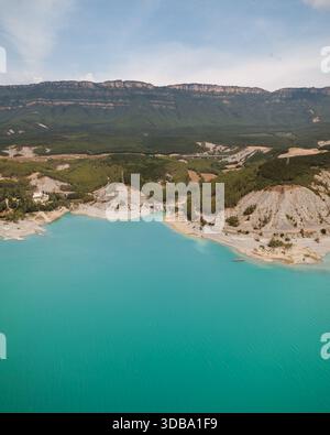 Aus der Vogelperspektive treffen Sie auf zerklüftete Klippen unter sanften Bergen, eine Symphonie aus Blau-, Grün- und Erdtönen, Sigues, Spanien. Stockfoto