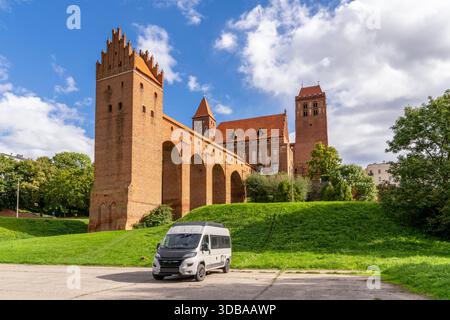 Kwidzyn, Polen - 23. September 2025: Blick auf die Burg Kwidzyn mit ihrem Wahrzeichen aus fünf Arkaden und einem Wohnmobil im Vordergrund Stockfoto