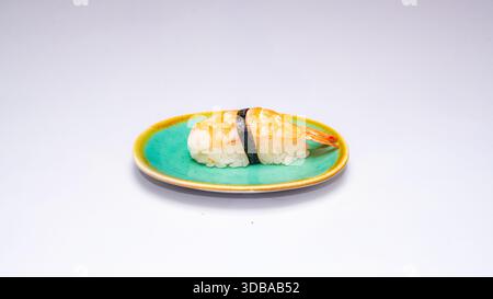 Klassisches Shrimp Nigiri Sushi serviert auf grüner Keramikplatte isoliert auf weißem Hintergrund. Stockfoto