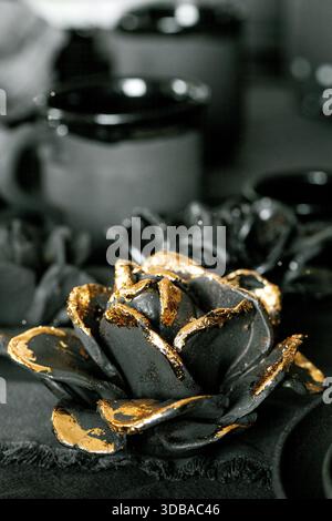 Rustikale Tischgestaltung mit leerem handgemachtem Keramikgeschirr, schwarzen Schüsseln, Tellern, Tassen, Kanne und Vase auf Leinentischdecken. BLCK-Keramikrosen fließen Stockfoto