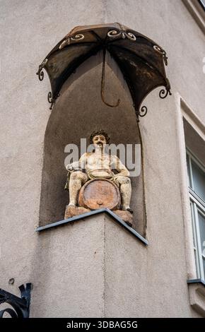 Skulptur von Bacchus (Dionysys) auf einem Weinfass, in einer Nische an einer Ecke von Grajski Trg, Maribor Stadtzentrum, Slowenien Stockfoto