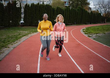 Verschiedene Frauen laufen auf Kurs, fördern einen gesunden aktiven Lebensstil Stockfoto