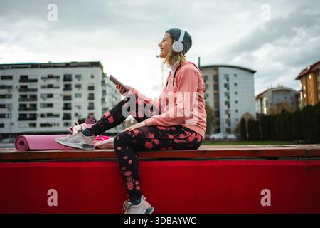 Frau, die sich im Stadtpark entspannt und Musik hört Stockfoto
