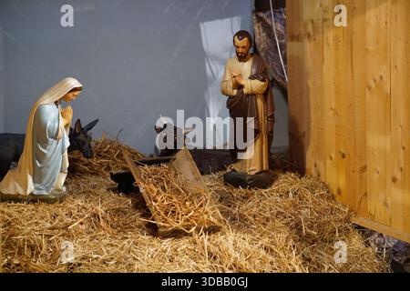 Krippe mit Statuen von Maria und Joseph neben einer leeren Krippe in einer Kirche in Nantes, Frankreich. Nantes, Frankreich Stockfoto