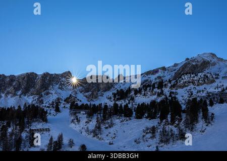 Ein atemberaubender Blick auf die österreichischen Alpen bei Sonnenaufgang. Die aufgehende Sonne wirft ein warmes Leuchten über die schneebedeckten Gipfel und Täler. Die Szene ist friedlich A Stockfoto