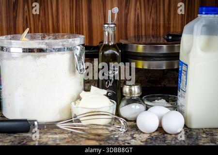 Waffelzutaten auf einer Küchentheke, mit Mehl, Eiern, Milch, Öl, und Kürzung für ein hausgemachtes Frühstücksrezept im Waukesha County. Stockfoto