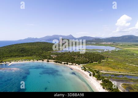 Aus der Vogelperspektive auf das türkisfarbene Wasser trifft auf die üppige grüne Landschaft, Kerentza Beach, Preveza, Griechenland. Stockfoto