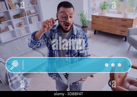 Überraschter junger Mann mit Lupe und Laptop zu Hause. Suchbegriff Stockfoto