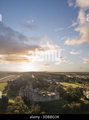 Blick aus der Vogelperspektive auf die verwitterten Steinmauern und die grüne Umgebung von Tantallon Castle treffen auf den weitläufigen Himmel, der im warmen Glanz der untergehenden Sonne, N, getaucht ist Stockfoto