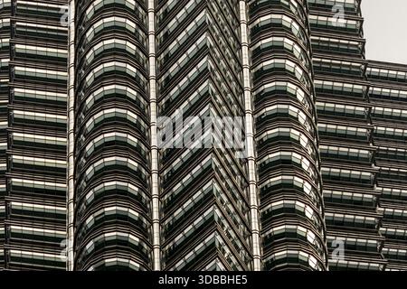 Der Blick auf die majestätischen Petronas Twin Towers erhebt sich mit geometrischer Präzision, deren Stahl- und Glasfassaden den Himmel in Kuala Lumpur, Federal Ter, reflektieren Stockfoto