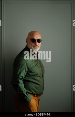Eleganter Mann In Passender Kleidung Mit Dunklen Farben Hinter Dezentem Hintergrund Stockfoto
