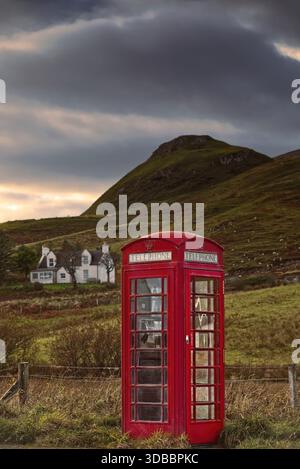 177 Rote Telefonzelle neben der A855 im Dorf Brogaig am Fuße der Quiraing-Landform, altes K6-Modell noch in Betrieb. Skye-Scotland. Stockfoto