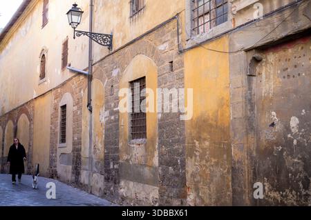 Eine Person läuft eine enge Straße in Florenz, Italien. Stockfoto