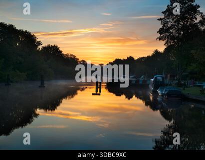 Blick vom Fußweg über das Abingdon Weir an der Themse, spektakulärer Wintersonnenaufgang Abingdon-on-Thames behauptet, die älteste Stadt Englands zu sein. Und die Themse fließt durch ihr Herz. In dieser idyllischen Szene sehen wir von den Abingdon Locks aus einen recht schönen Blick auf den Fluss, gerade während die Sonne an einem schönen Wintermorgen aufgeht. So ruhig... Stockfoto