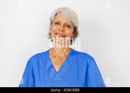 Porträt einer selbstbewussten Ärztin mittleren Alters in blauer Uniform Stockfoto