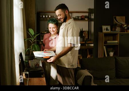 Junge Frau und junger Mann hören gemeinsam Vinyl-Platten Stockfoto