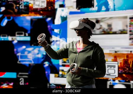 Frau, die Virtual-Reality-Technologie nutzt, um Videoempfehlungen sofort zu erhalten. Benutzer mit VR-Headset-Ausrüstung im digitalen Zeitalter, das unbegrenzte Streaming-Möglichkeiten ermöglicht Stockfoto