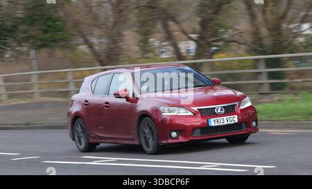 Milton Keynes, Bucks, UK - 11. Dezember 2025: 2013 rotes Lexus CT Hybrid-Elektroauto, das auf einer britischen Straße fährt Stockfoto