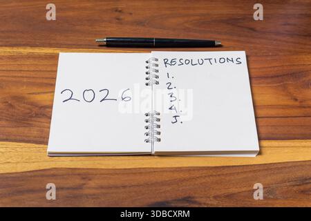 Neujahrskonzept 2026. Notizbuch und Stift auf Holztisch Stockfoto