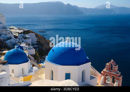 Blaue Kuppelkirchen mit Blick auf die Santorini-Caldera von Fira, Griechenland. Stockfoto