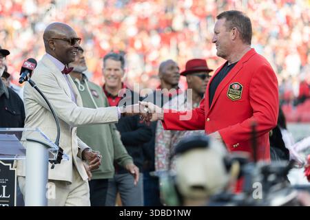 Dezember 2025; Santa Clara, Kalifornien, USA; der pensionierte San Francisco 49ers Tight End Brent Jones schüttelt die Hände mit dem ehemaligen Teamkollegen Jerry Rice, bevor er während der Halbzeitshow zwischen den San Francisco 49ers und den Tennessee Titans im Levi’s Stadium in die Edward J. DeBartolo SR 49ers Hall of Fame einstieg. Obligatorische Gutschrift: Stan Szeto-Image of Sport Stockfoto