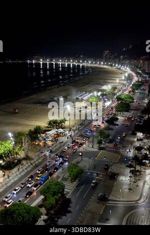 Der Abendverkehr schleicht in Richtung Norden entlang der Avenida Atlantica am Strand von Copacabana in Rio de Janeiro, Brasilien. Stockfoto