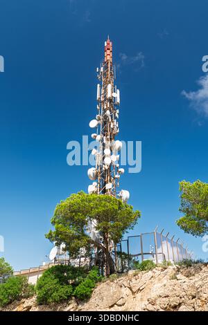 Telekommunikationsturm auf Rocky Hilltop gegen Clear Blue Sky, Mallorca, Spanien Stockfoto