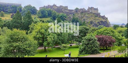 Ein atemberaubender Blick auf Edinburgh Castle auf seinem felsigen Barsch, von der Princes Street aus gesehen, umgeben von üppigem Grün und im Sommerlicht getaucht. Stockfoto