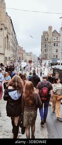 Ein lebhafter Spaziergang entlang der alten Royal Mile in der Nähe von Edinburgh Castle, gefüllt mit Menschenmassen und Touristen, die die Geschichte, Atmosphäre und das pulsierende Straßenleben von Schottlands Hauptstadt genießen Stockfoto