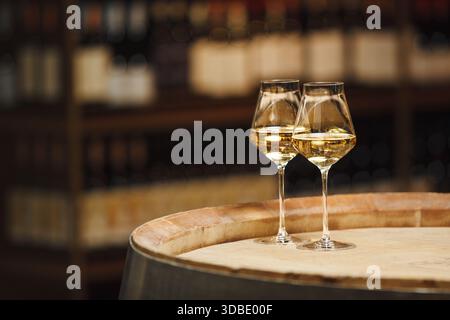 Zwei Gläser Weißwein auf Holzfässern im Weingut Stockfoto