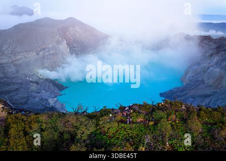 Spektakulärer Vulkan Ijen auf der Insel Java in Indonesien, Blick aus der Vogelperspektive auf einen Vulkankrater und einen blauen vulkanischen See mit dampfenden Lüftungsöffnungen bei Sonnenaufgang Stockfoto