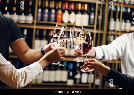Menschen in guter Stimmung klirren Gläser, feiern zusammen, Foto Fokus auf Hände Frau und Mann Verkostung verschiedene Arten von Wein, Alkohol Stockfoto