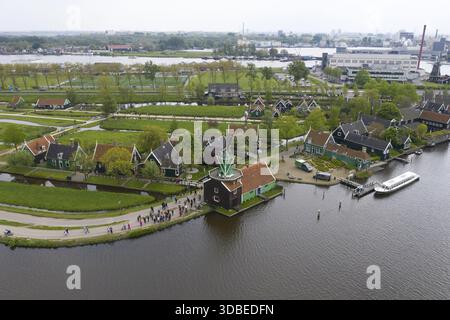 Blick aus der Vogelperspektive auf das malerische Dorf Zaanse Schans mit seinen berühmten grünen Holzhäusern und Windmühlen, die sich im ruhigen Wasser spiegeln, Zaandijk, Zaandam, Stockfoto