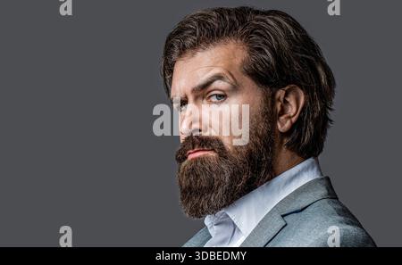Nahaufnahme Porträt eines gutaussehenden Geschäftsmannes im formalen Anzug. Porträt eines selbstbewussten Geschäftsmannes, Anzug mit Bart und Haaren allein, der ernsthaft aussieht Stockfoto