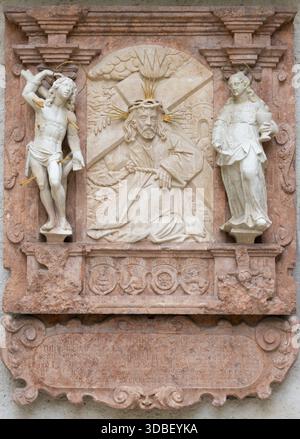 SALZBURG, AUSTIRA - 8. SEPTEMBER 2025: Das Steinrelief Jesu mit dem Kreuz an der Außenwand der Margarethenkapelle Stockfoto