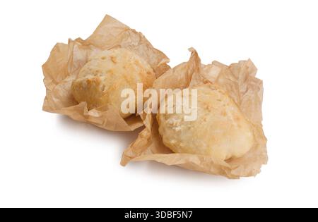Studio-Aufnahme von Sauerteigerrollen, die in Backpapier gewickelt sind und vor weißem Hintergrund ausgeschnitten wurden Stockfoto
