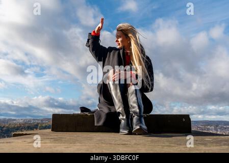 Frau sitzt und genießt einen sonnigen Wintertag im Dezember Stockfoto